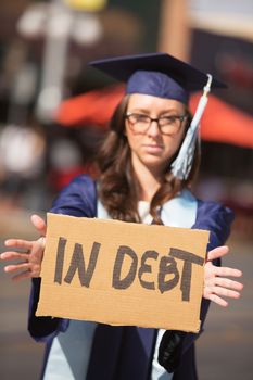 Disappointed young woman holding cardboard debt sign