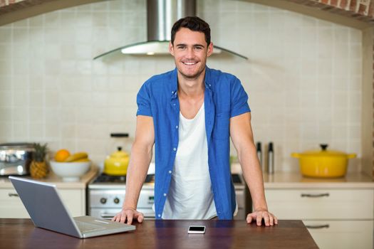 young man leaning on kitchen worktop