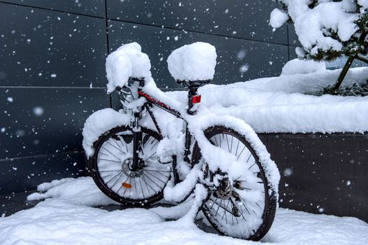 Bycicle covered by snow.