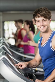 Smiling muscular man on treadmill 