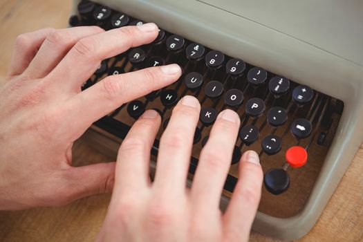 Close up of masculine hands typing on old typewriter