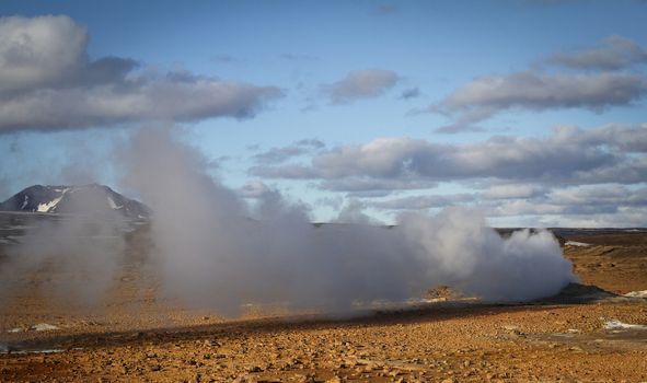 Horizontal view of steam hot springs coming out of the ground in the volcanic valley near Myvatn baths in Iceland