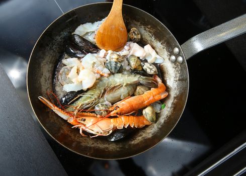 Seafood and shrimp are fried in a pan
