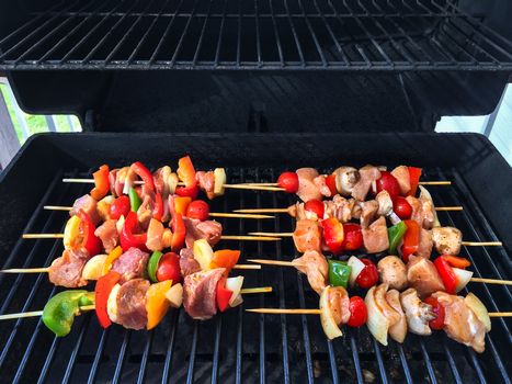 Meat and vegetable skewers on a barbecue grill