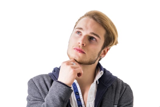 Attractive young man thinking, looking up unsure