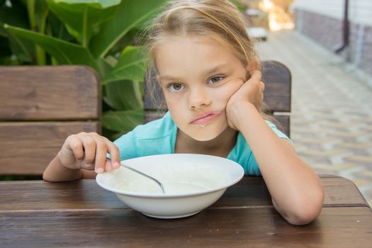 Six year old girl does not want to eat porridge for breakfast