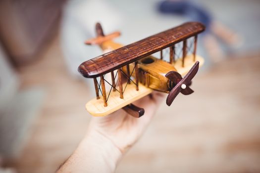 Cropped hand playing with wooden airplane