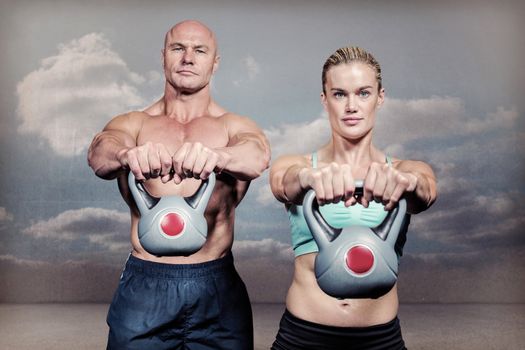 Composite image of portrait of muscular man and woman lifting kettlebells