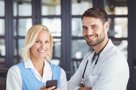 Portrait of smiling doctors using mobile phone