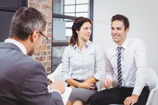 Business professional discussing with smiling clients