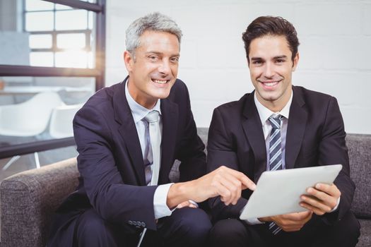 Portrait of smiling businessmen with digital tablet 