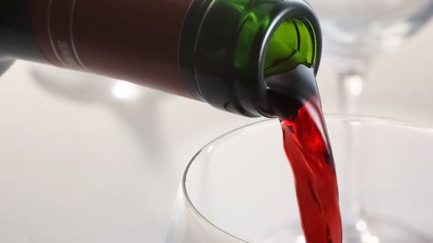 Red wine being poured to a glass.