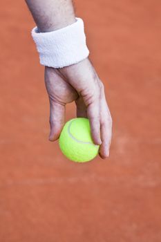 tennis ball in hand, preapring to serve