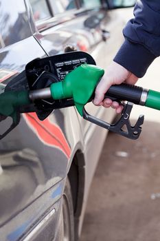 man filling up a car with fuel at petrol station
