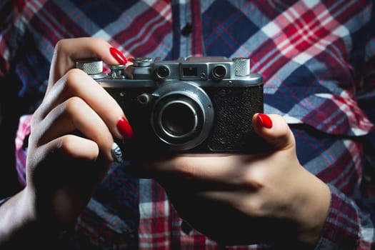 Closeup of retro camera in hipster girl hands