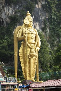 Photo of lord murugan statue standing tall in front the cave entrance taken during Thaipusam at Batu Cave temple, Malaysia .