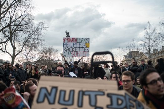 FRANCE, Paris: A man holds a placard reading #PanamaLeaks, People, Enough of extorsions referring to the massive data leak called Panama Papers as hundreds of militants of the Nuit Debout or Standing night movement hold a general assembly to vote about the developments of the movement at the Place de la Republique in Paris on April 4, 2016. It has been five days that hundred of people have occupied the square to show, at first, their opposition to the labour reforms in the wake of the nationwide demonstration which took place on March 31, 2016. 