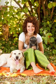 Young beautiful woman relaxing in nature with pets