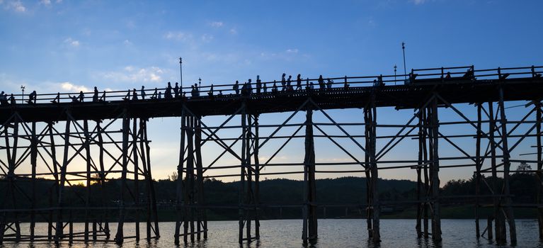 silhouette of Utamanusorn Bridge (Mon Bridge), made from wooden 