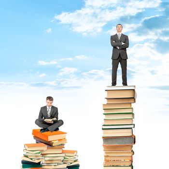 Businessman sitting on stack of books 