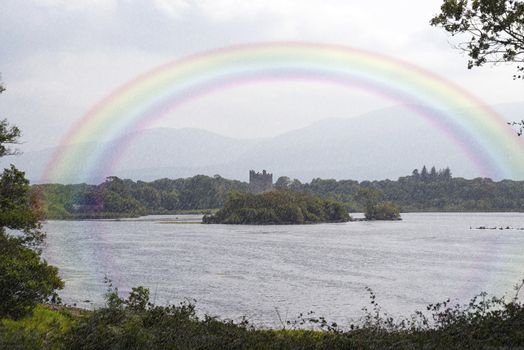 rainbow view of ross castle and lake from a killarney forest in ireland