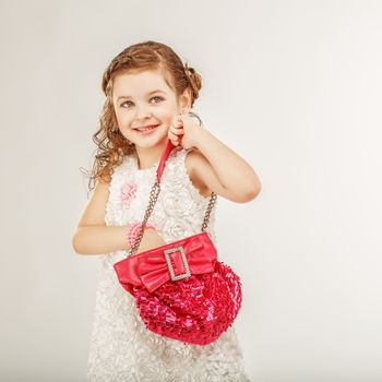 little girl holding a pink handbag