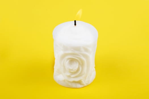 Carved white candle on yellow background