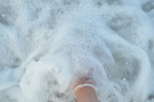 Foot on the sandy sea