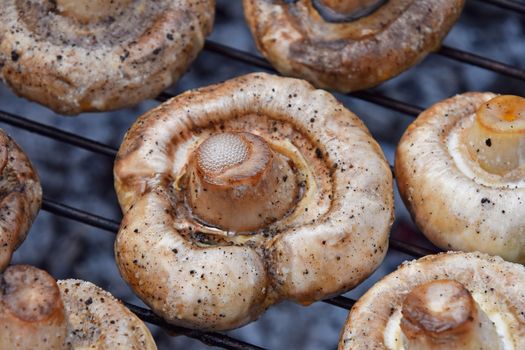 White champignons mushrooms on grill