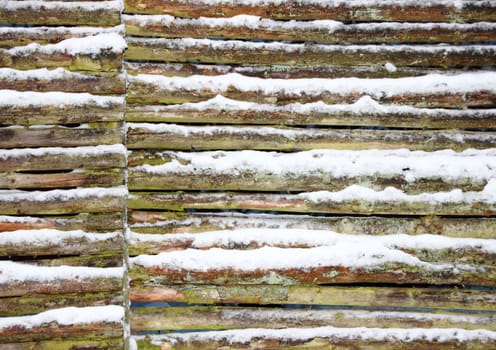 Connected wooden fence wall with snow in winter