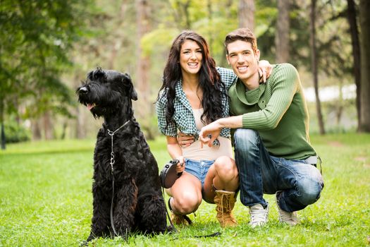 Young Couple With Black Giant Schnauzer