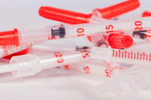 Pile of Empty Syringes with Red Safety Caps