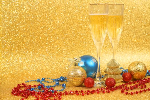 Champagne and christmas decor on golden glitter background with copy space