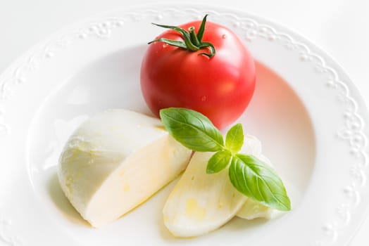 Mozzarella, tomato and fresh basil as caprese salad ingredients