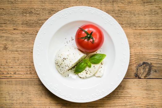 Mozzarella with tomato and fresh basil as caprese salad ingredie