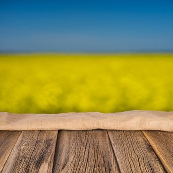 empty wooden planks with blurred background blooming yellow rape