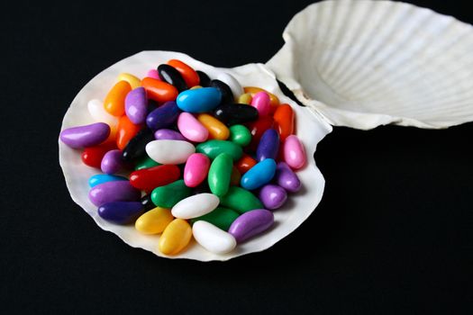 Multi colored candies on a tray with black background