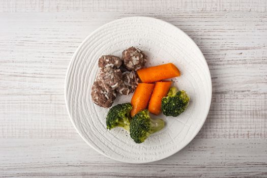 Steamed broccoli and carrots with meatballs
