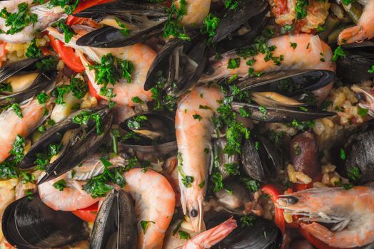 Paella with seafood  and greens background close-up