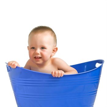 Cute baby boy playing in a blue plastic tub.