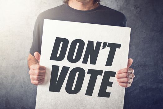 Man holding poster with Don't vote title