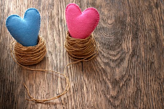 Love hearts handmade on wooden background. Valentines  Day. Couple in nests. Vintage romantic style. Vivid greeting card, multicolored felt