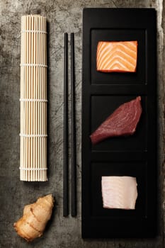 assortment of raw fish and ingredients for making sushi