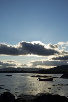 boat in a quiet bay near kenmare on the wild atlantic way ireland at sunset