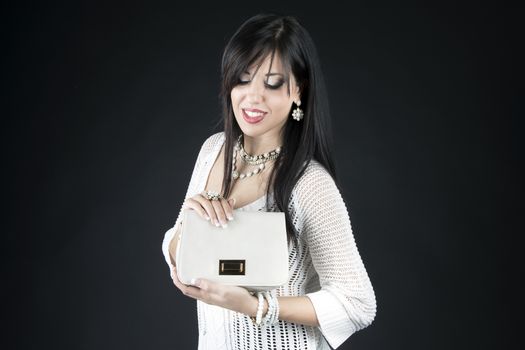 Beautiful woman with evening make-up. Jewelry, bag and Beauty.