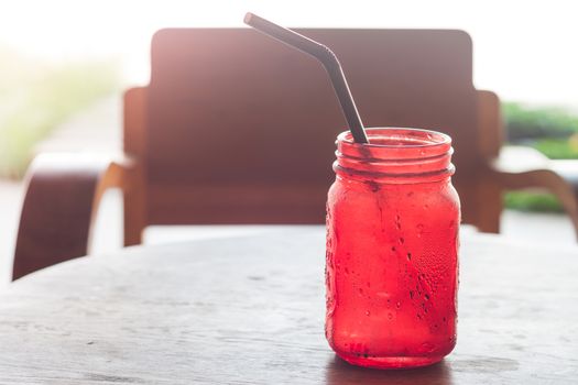 Iced drink in red glass on wooden table