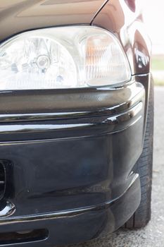 Closeup headlight of black coupe