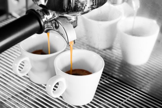 Prepares espresso in coffee shop with black and white background