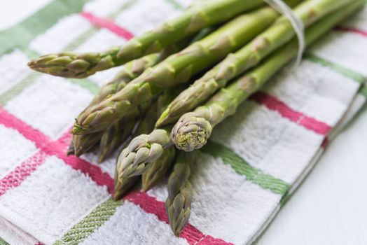 Bunch of fresh asparagus on kitchen cloth closeup