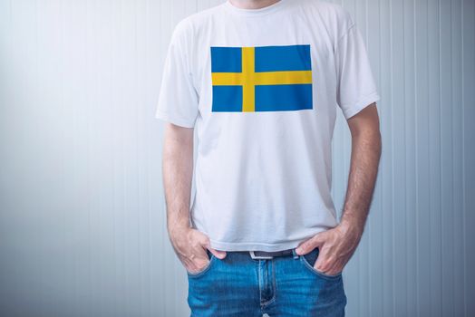 Handsome casual man wearing white t-shirt with Swedish flag